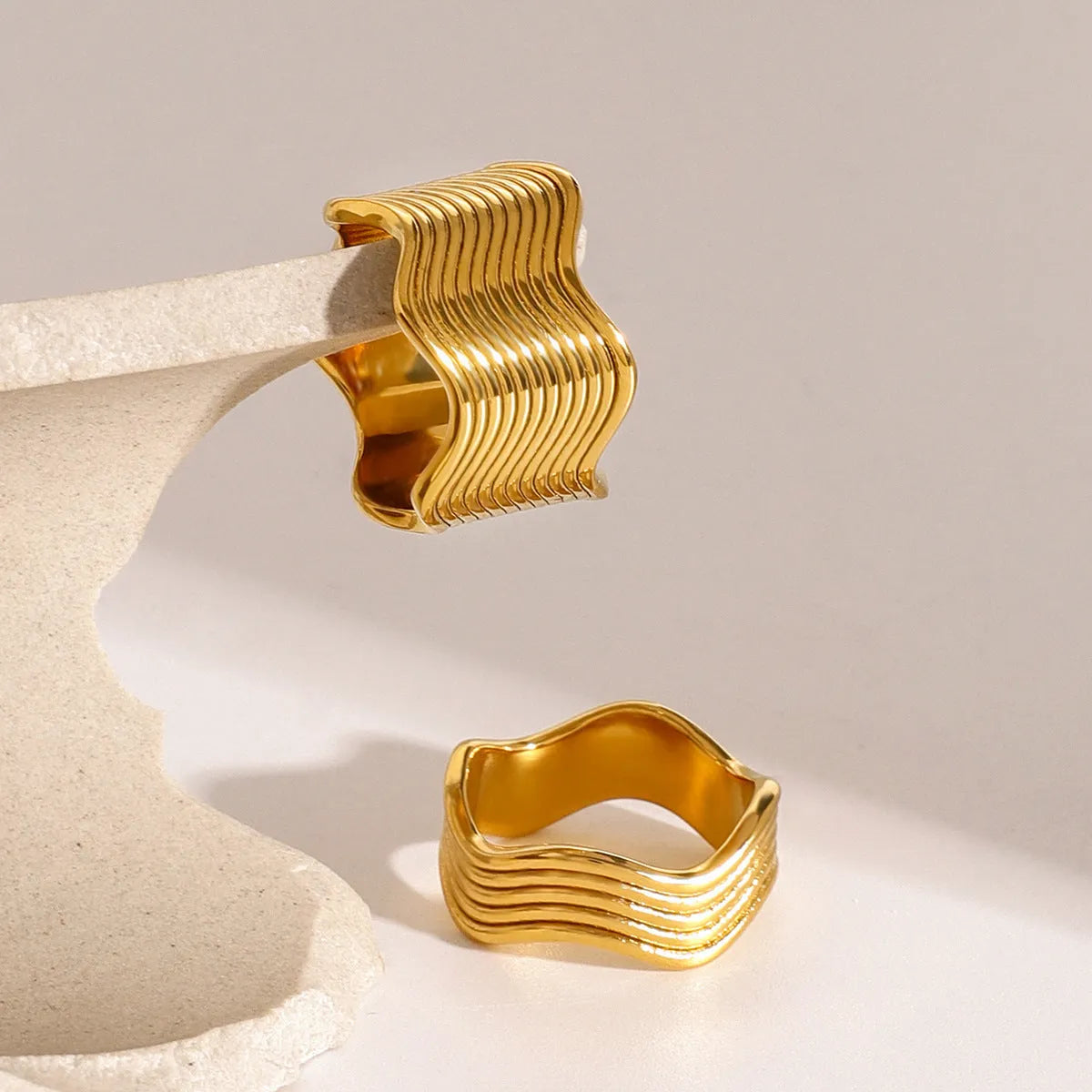 Geometric wave pattern on a stainless steel wide band ring in an electroplated colour finish.