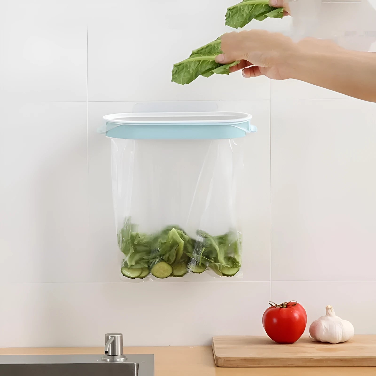 Blue plastic kitchen garbage bag storage rack mounted on a cabinet door.