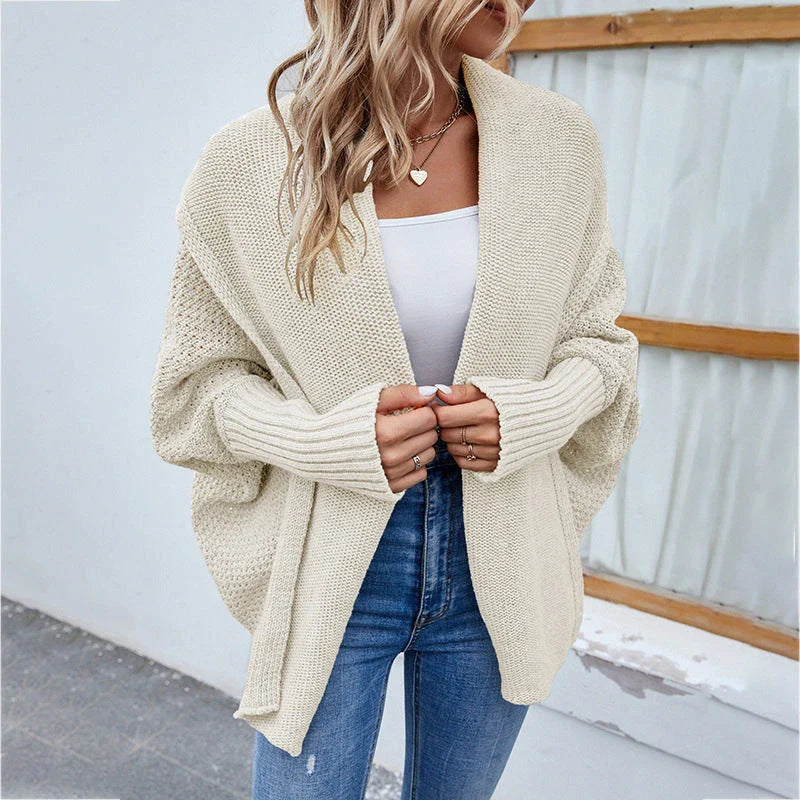 A cozy, oversized knit cardigan with a unique bat-wing sleeve design and large lapel, available in a variety of stylish colors.