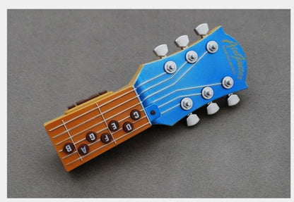 Compact infrared electronic guitar with chord buttons and tilt sensor in red, blue, or black