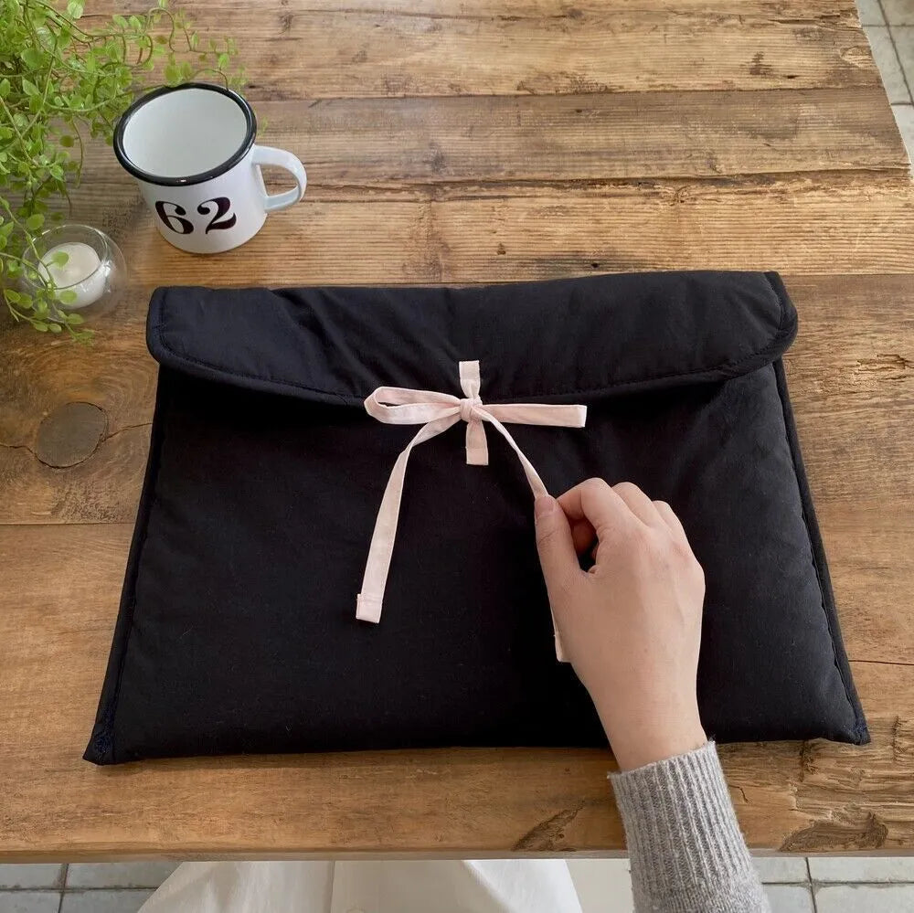 Women's black and white quilted laptop bag with ballet-style bow and striped nylon pattern