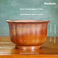 Indoor antique carved purple sand ceramic flowerpot in S1696 firewood colour on a wooden surface.
