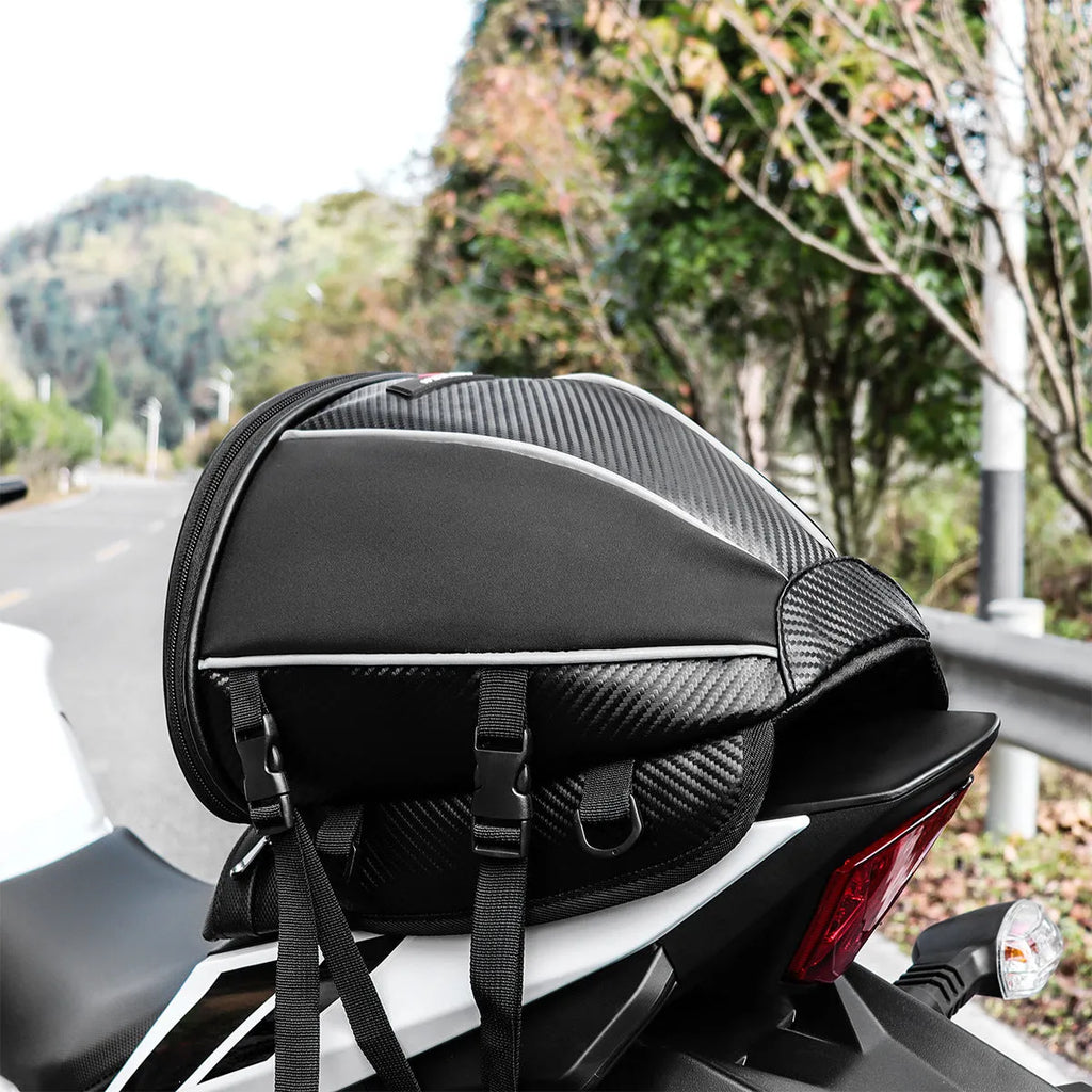 Black motorcycle seat bag with reflective strip, showing convertible crossbody strap and internal pocket organisation