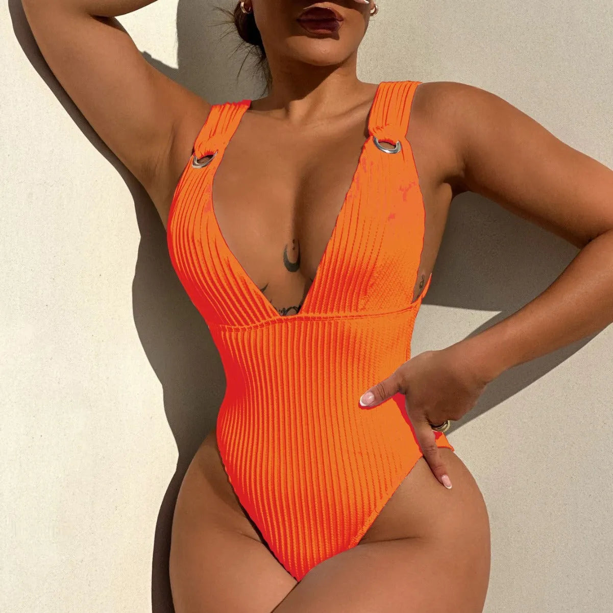 Women's solid colour one-piece swimsuit on a hanger, shown in black, white, green, and orange colour options.