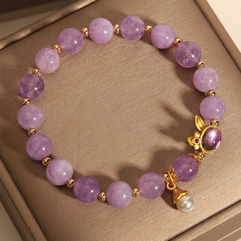 Natural mauve jade rabbit bracelet with crystal band and purplish red hare head charm.