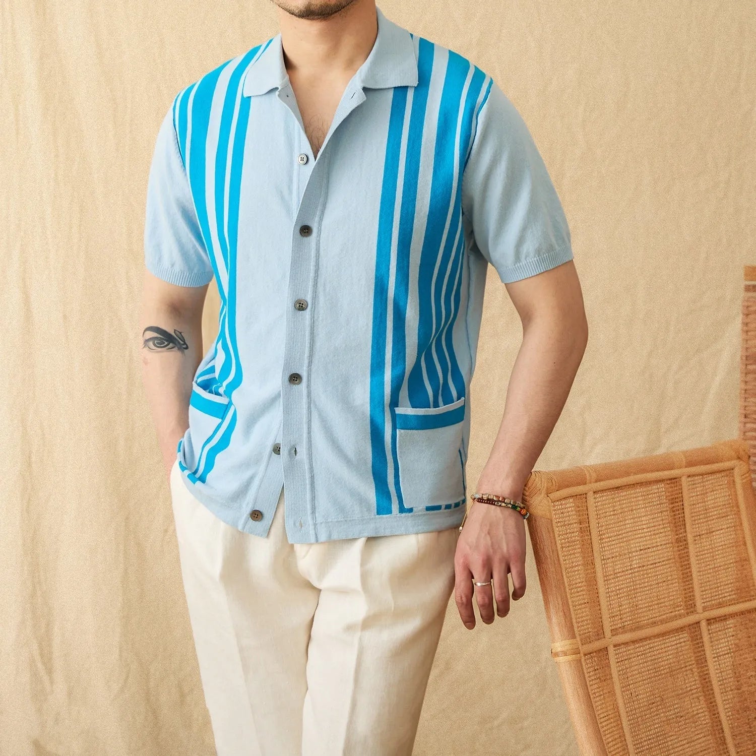 A striped royal blue short-sleeved polo cardigan shirt with a lapel collar, laid flat.