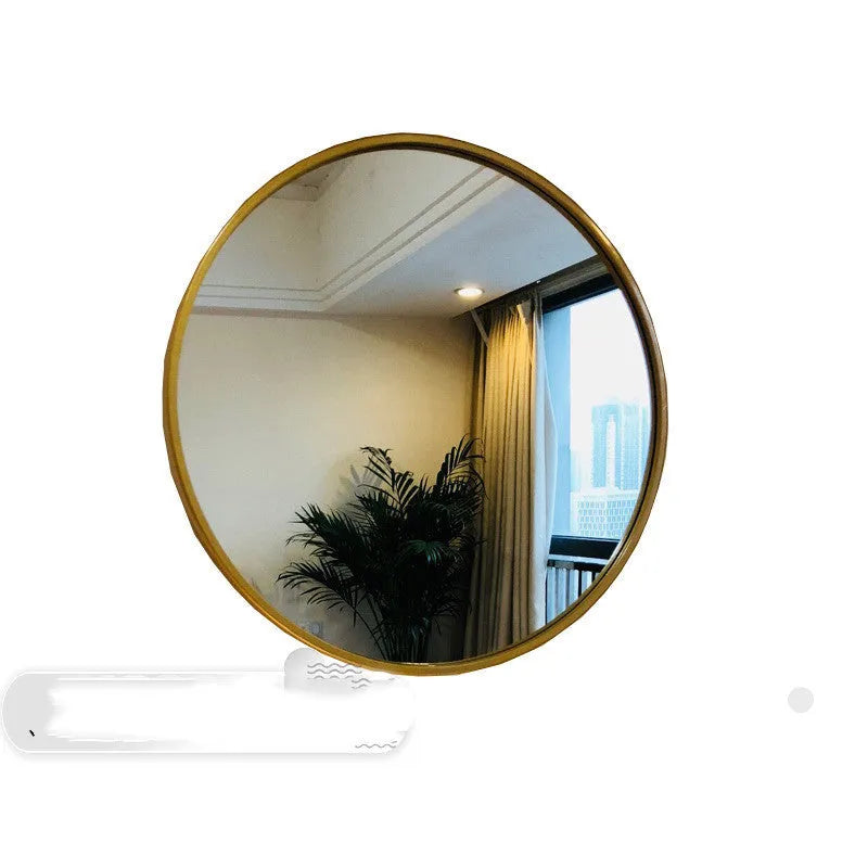 Round metal-framed wall mirror in black, white, or gold, shown in a bathroom setting.