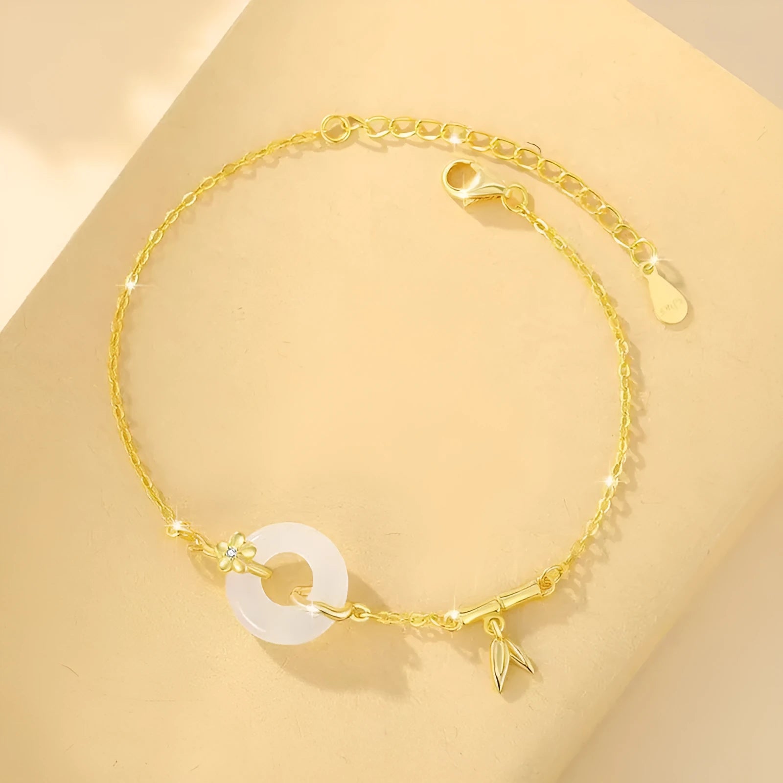 Gold-coloured women's silver bracelet with a peace buckle design and white chalcedony stone centrepiece.