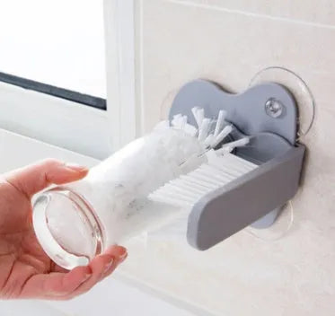 Grey double-headed cup cleaning brush with wall-mounted suction cups for kitchen use