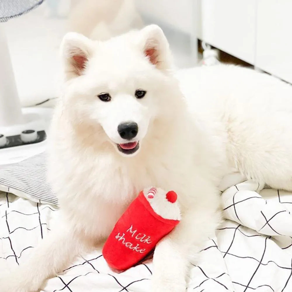 A selection of soft plush pet toys in hamburger, french fries, and milkshake cup designs.