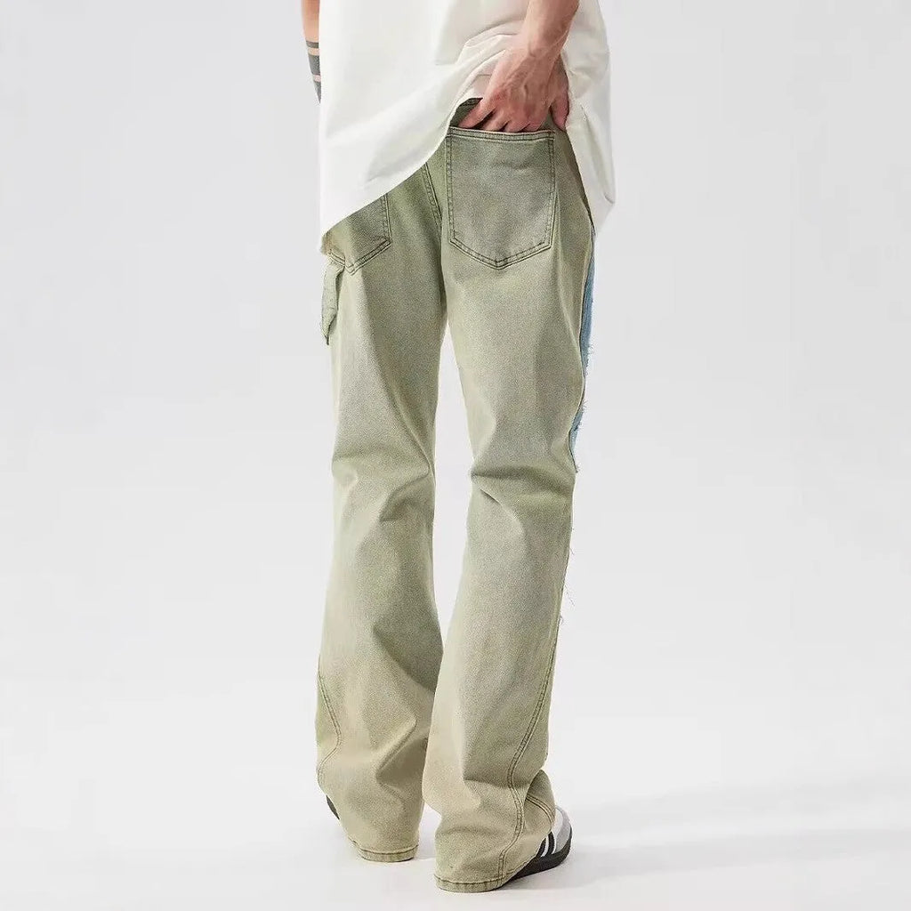 Yellow and blue retro patchwork jeans with splash-ink distressed design on a mid-waist trouser cut.