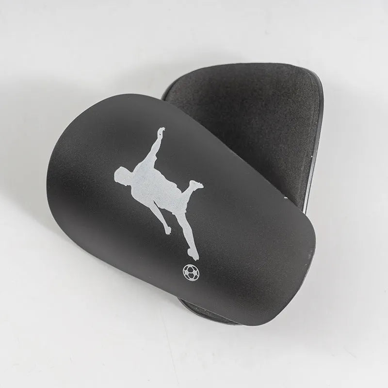 Mini football leg protector in black PU material, size XS, measuring 8 cm by 5 cm