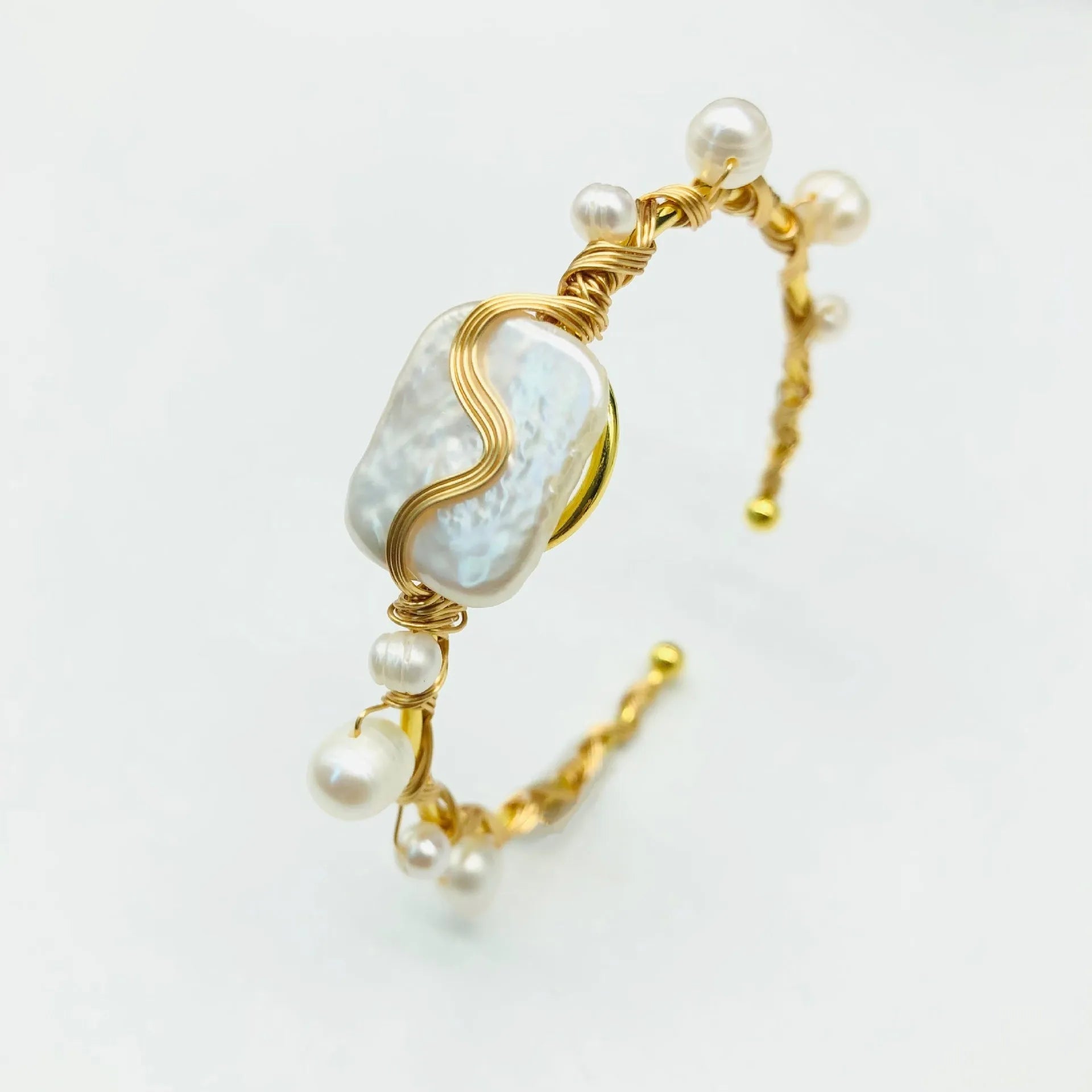Natural freshwater pearl bracelet with gold titanium steel wire-wrap on hand model