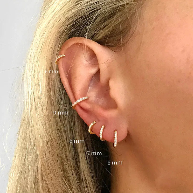Gold, rose gold, and silver colour perforated circle zircon stud earrings in various sizes on a white background.
