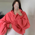 Watermelon red women's loose mulberry silk hooded sweater on a hanger.