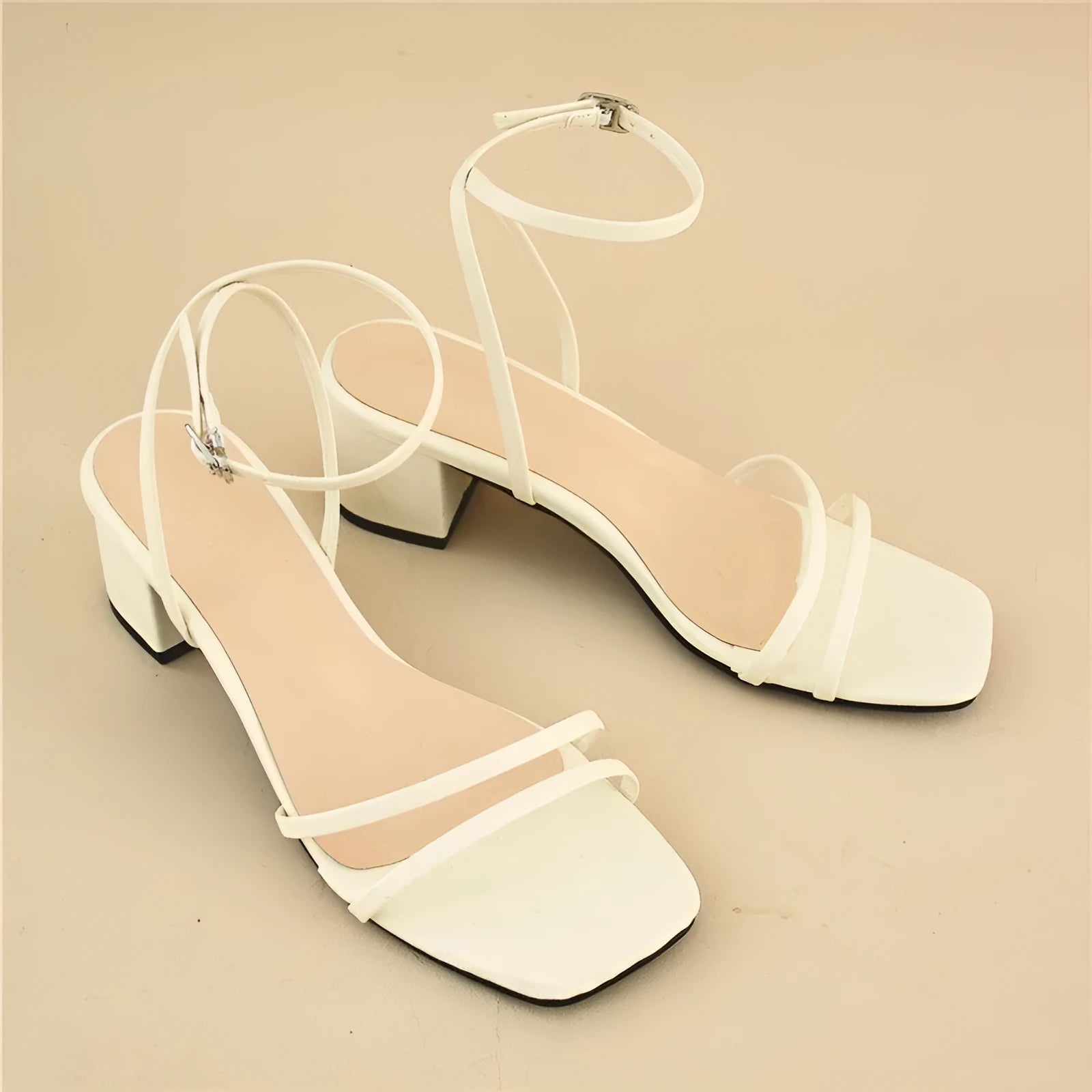 Beige women's stiletto sandals with a chunky block heel and an adjustable ankle buckle strap.
