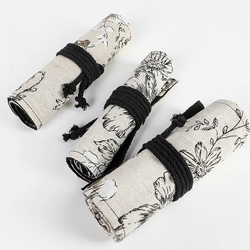 Black peony floral print pencil roll bag open to show multiple pencil slots.