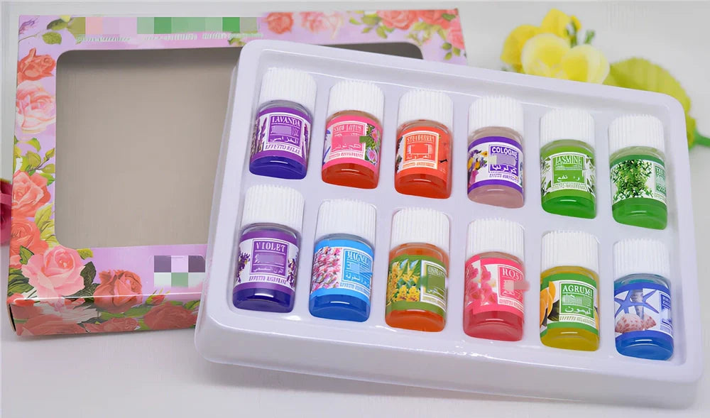 Box of 12 round plastic aromatherapy oil bottles, 25-50mL, featuring lemon, rose, jasmine, lavender floral scents