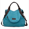 Women's canvas handbag in lake blue with zipper closure, hard handle, and double strap roots for shoulder or crossbody carry