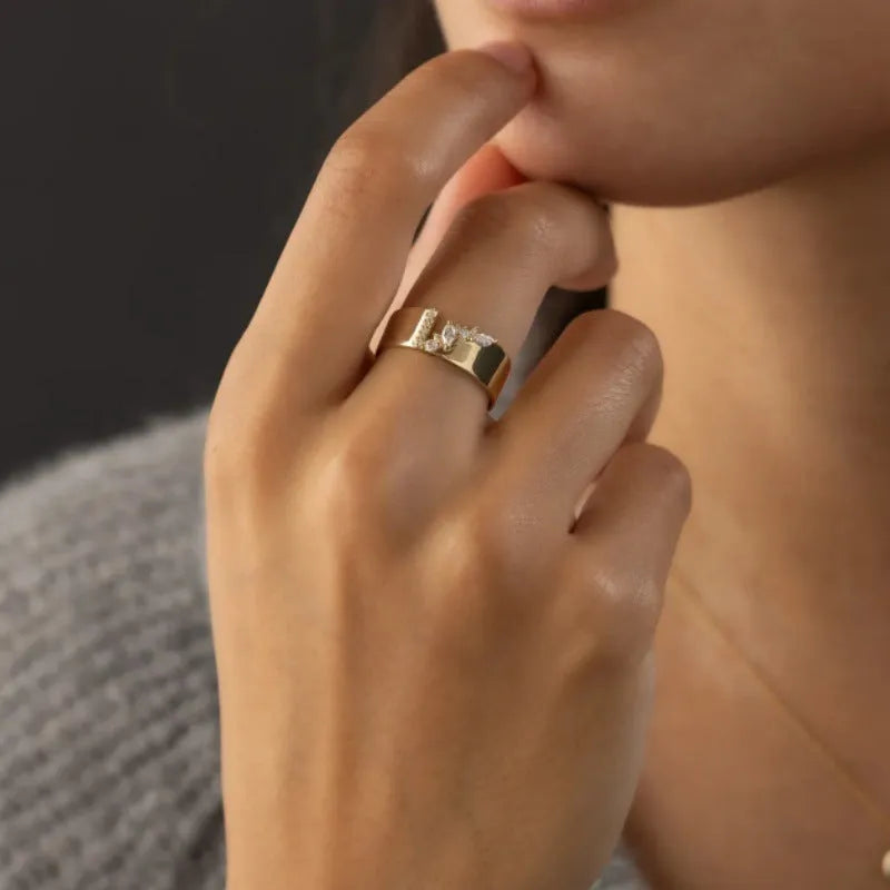 Gold-coloured women's fashion ring with shining zircon stones on a metal band