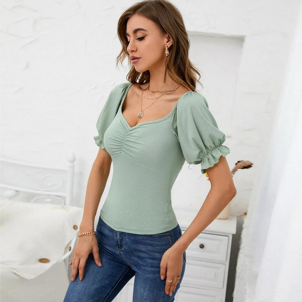 Women's light green slim-fit puff-sleeve knit top with shirred waist and ruffle trim on model