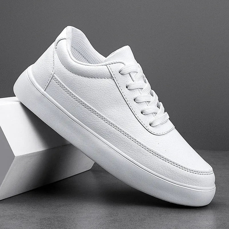 Women's white leather casual flat shoes with front lace-up design on a plain background.