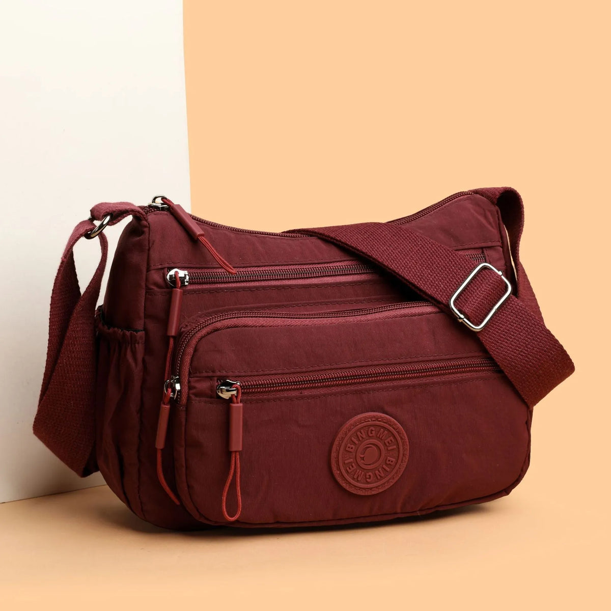 Grey water-repellent nylon crossbody bag showing three-dimensional pockets and a single shoulder strap.