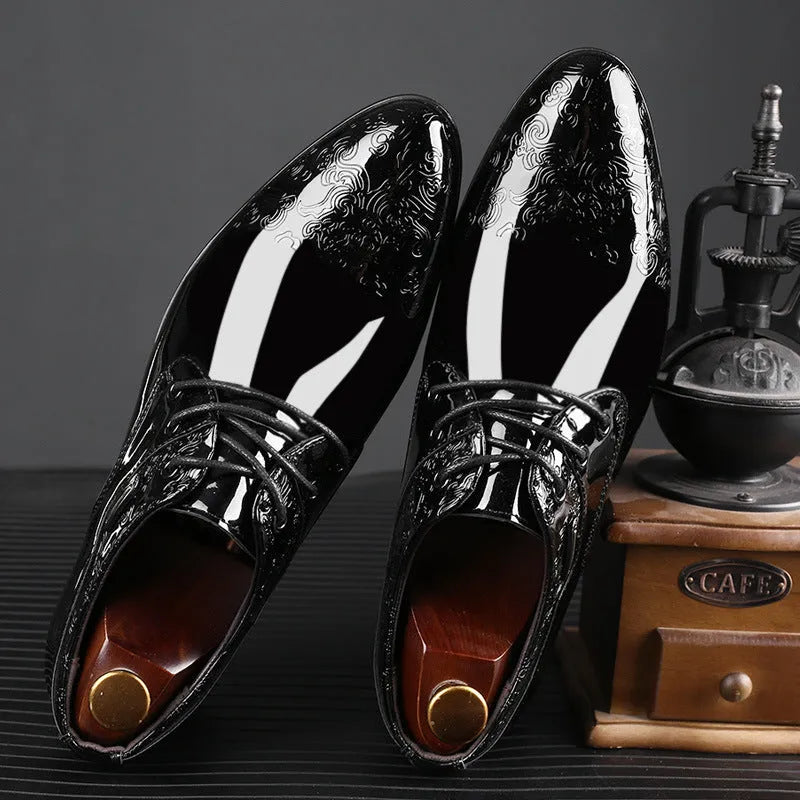 Glossy black men's formal shoes with pointed toe, low top, and carved detail on microfiber leather upper