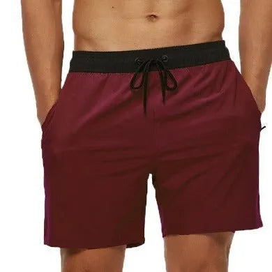 Men's blue drawstring fitness shorts with a zippered side pocket and stitching detail on the waistband.
