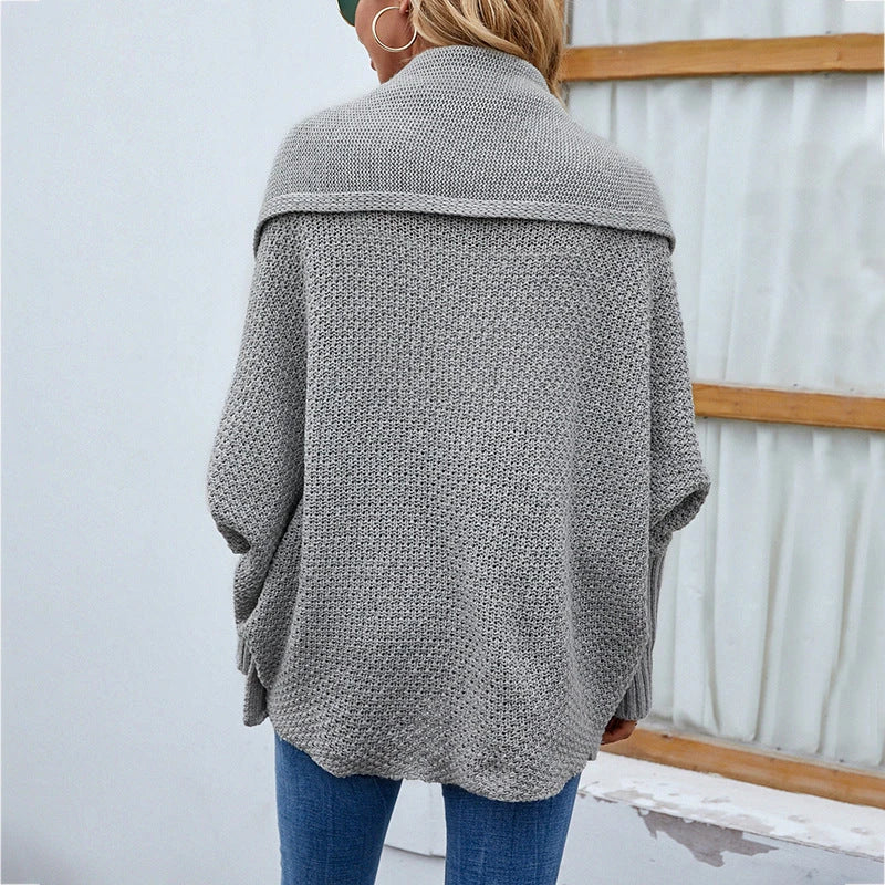 A cozy, oversized knit cardigan with a unique bat-wing sleeve design and large lapel, available in a variety of stylish colors.