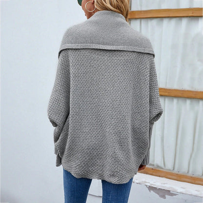 A cozy, oversized knit cardigan with a unique bat-wing sleeve design and large lapel, available in a variety of stylish colors.