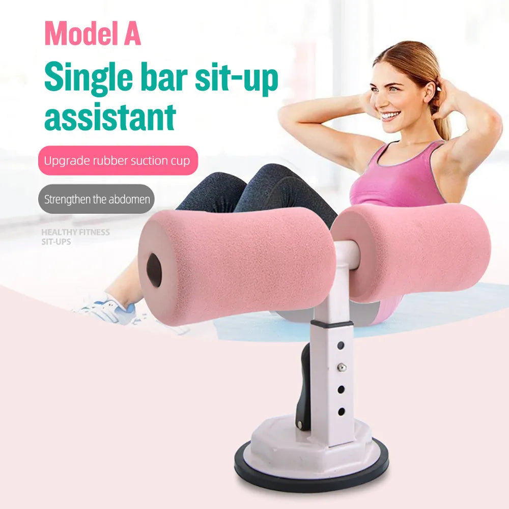 Pink adjustable sit-up bar with foam handles and suction base on a smooth floor for home fitness
