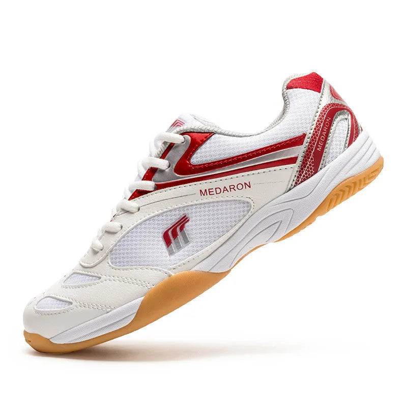 White and red mesh table tennis sneakers with rubber sole and lace-up front.