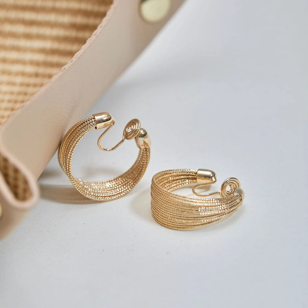 Set of four geometric earring pairs in silver and gold, including stud and clip styles