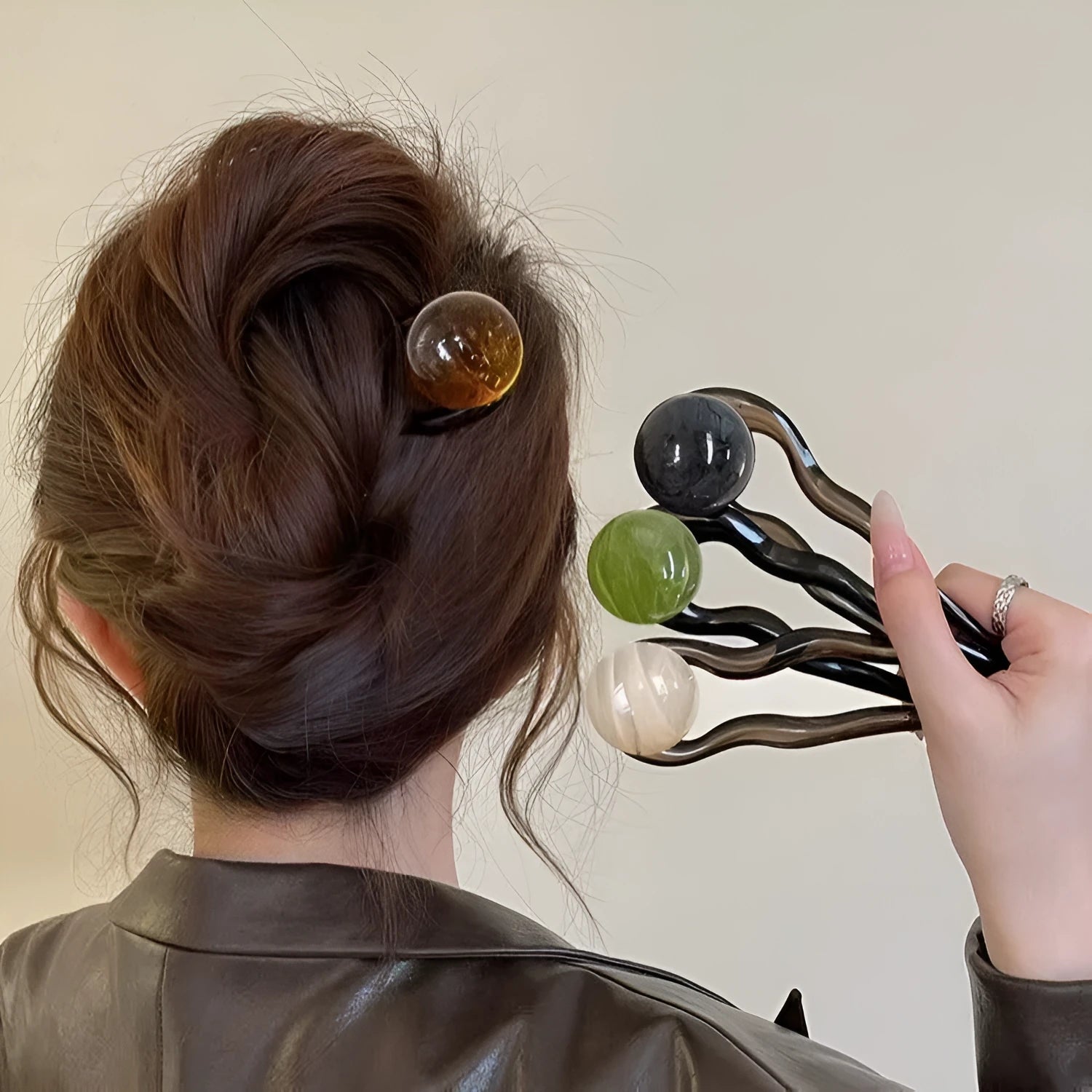 A set of simple U-shaped acrylic hair barrettes with a retro ball detail in beige and caramel colours.