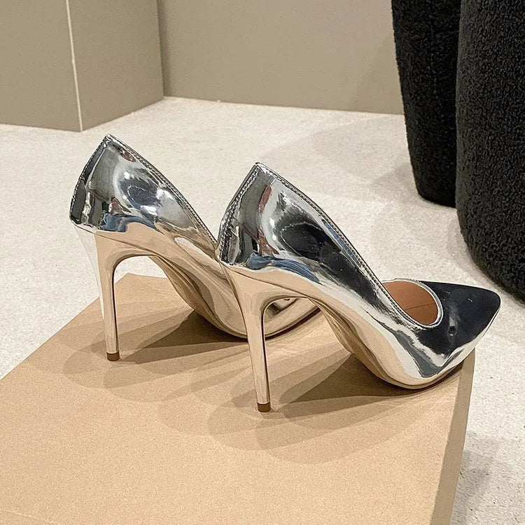 Gold and silver pointed toe slip-on pumps with stiletto heel on white background