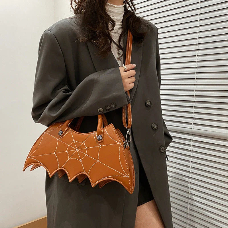 A stylish PU leather shoulder bag with a unique spider web and Batgirl-inspired design, available in a variety of vibrant colors.