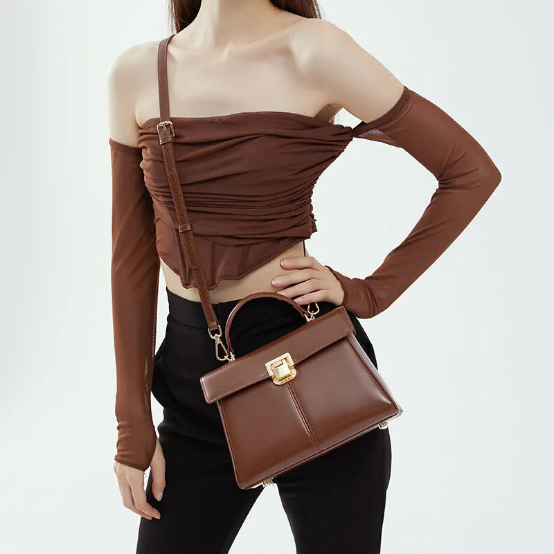Black genuine leather women's shoulder bag with vachette clasp and long strap.