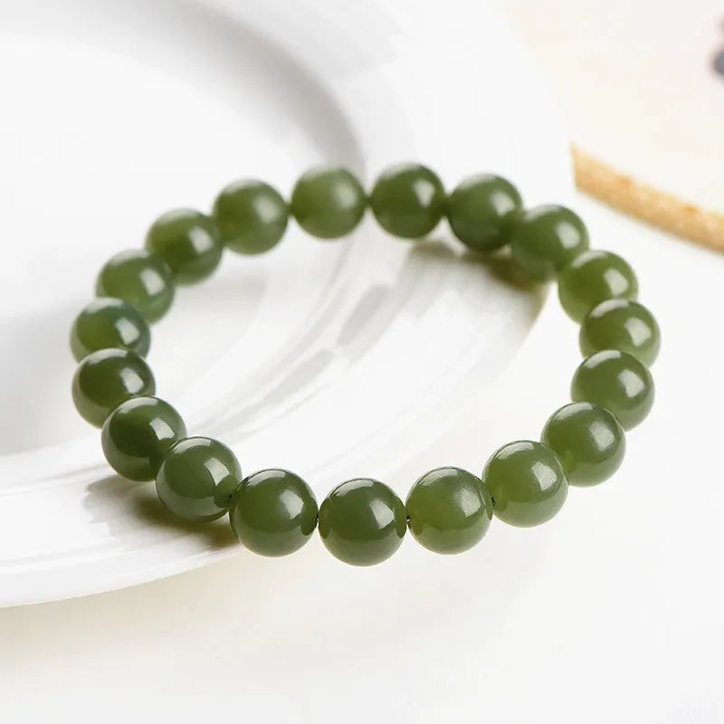 Polished Hetian jade beaded bracelet on a wrist, showing ice-like clear colour tones and spherical beads.