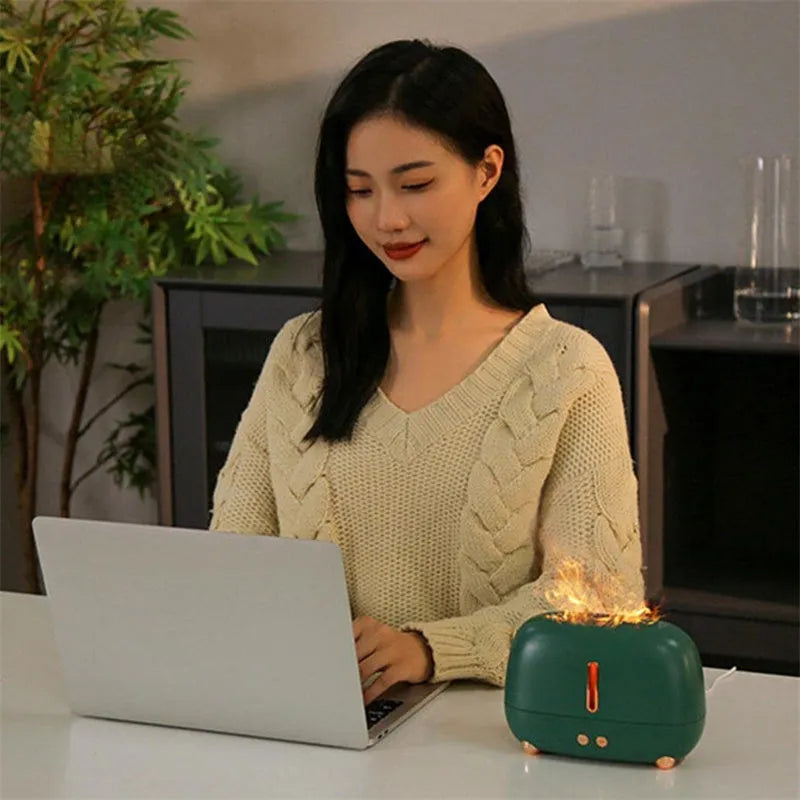 Dark grey flame humidifier with realistic orange LED light and mist output on a wooden table