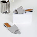 Women's flat denim slippers with a tassel decoration in apricot colour.