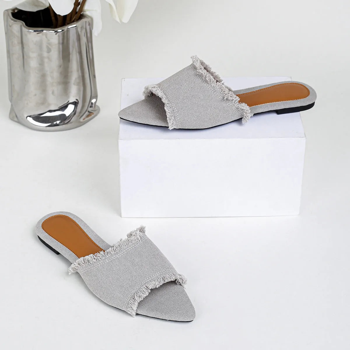 Women's flat denim slippers with a tassel decoration in apricot colour.