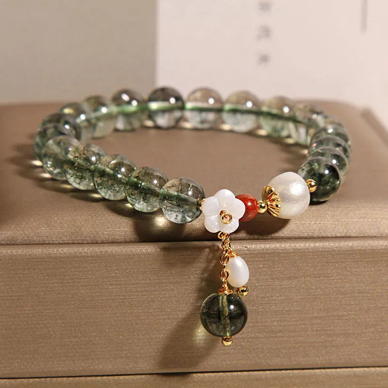 Green phantom quartz crystal bracelet for women with a small white shell flower accent.