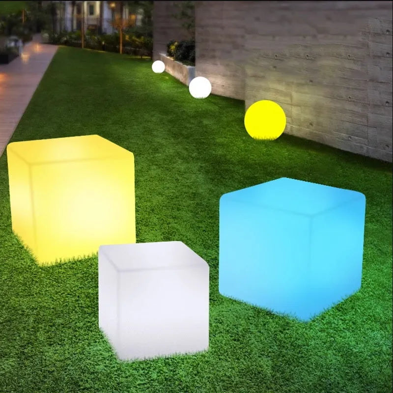 A modern white LED cube light stool sitting outdoors on a patio.