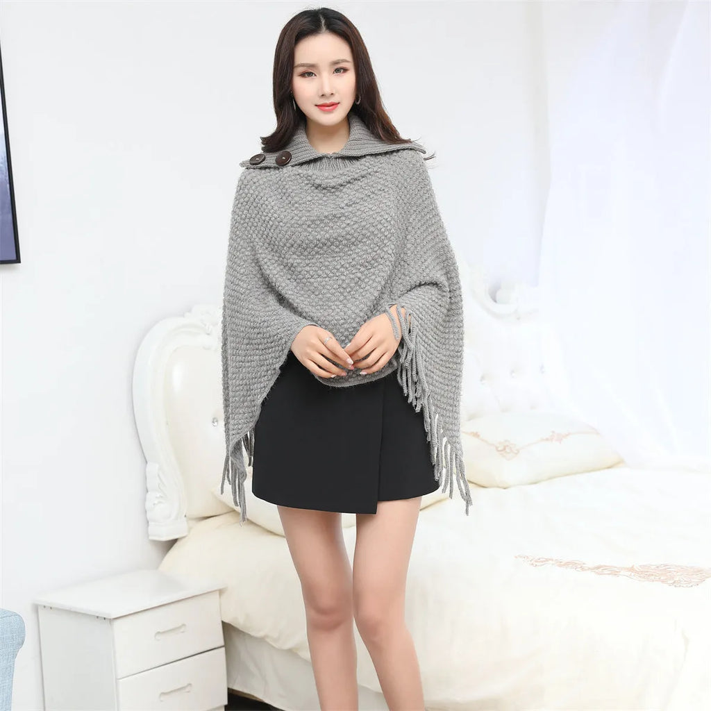 Sleeveless dot pattern knit cloak poncho in apricot colour, laid flat.
