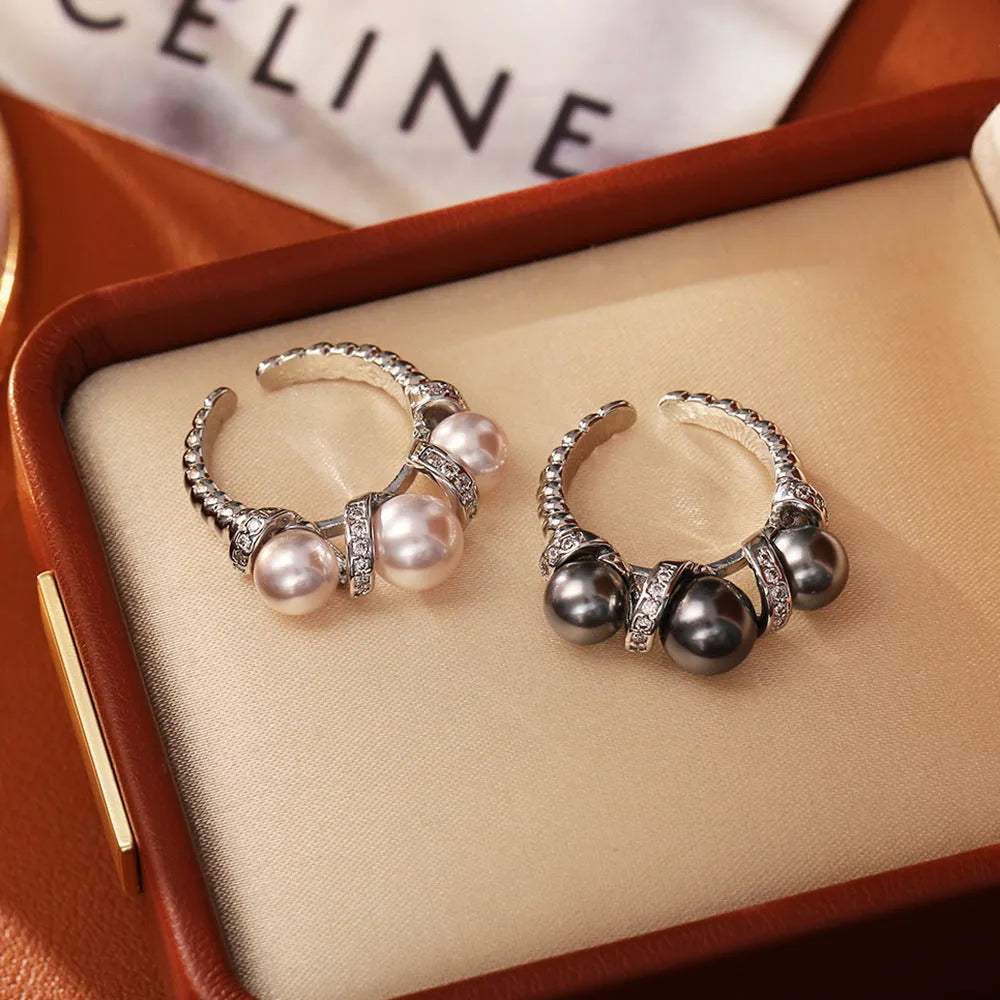 Real gold plated copper open-end ring with round pearl in geometric setting, grey colour, on a neutral background