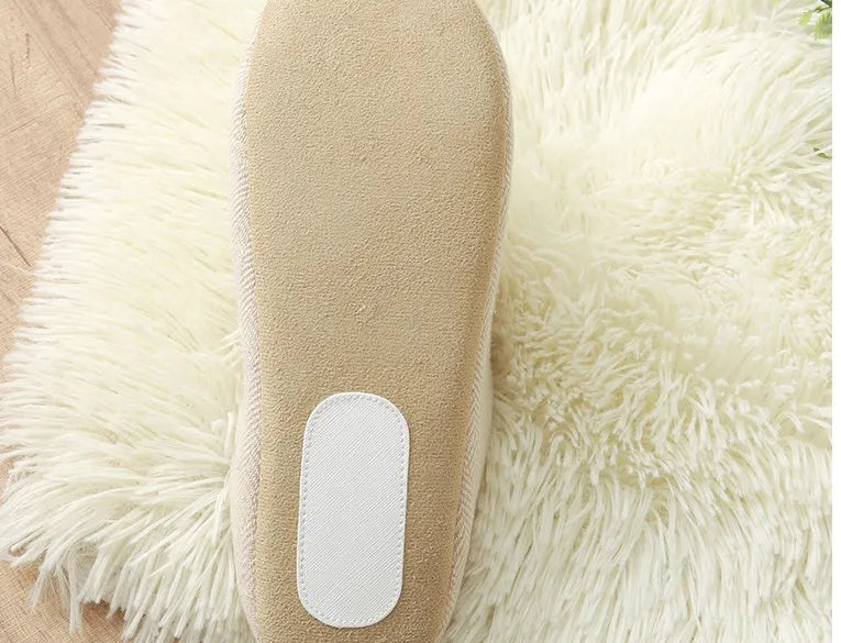 Men's black cotton indoor slippers with soft anti-skid sole on a wooden floor