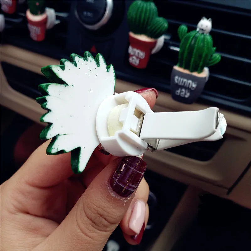 Car air freshener vent clip in plant ornament style, attached to car air conditioning vent