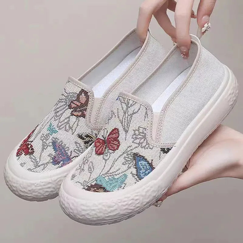 Women's canvas slip-on shoes with plastic soles in black and white colours showing sewing thread decoration