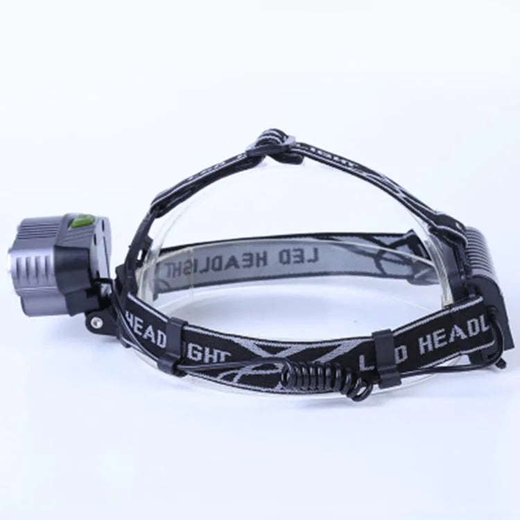 Fixed focus LED head torch with head strap, shown illuminating a long distance.